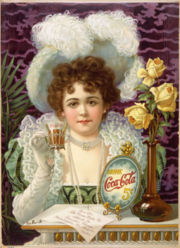 Eine Frau mit großem Hut hält ein Glas Coca-Cola