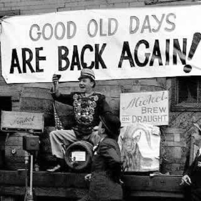 Menschen feiern unter einem Transparent mit der Aufschrift Good old days are back again